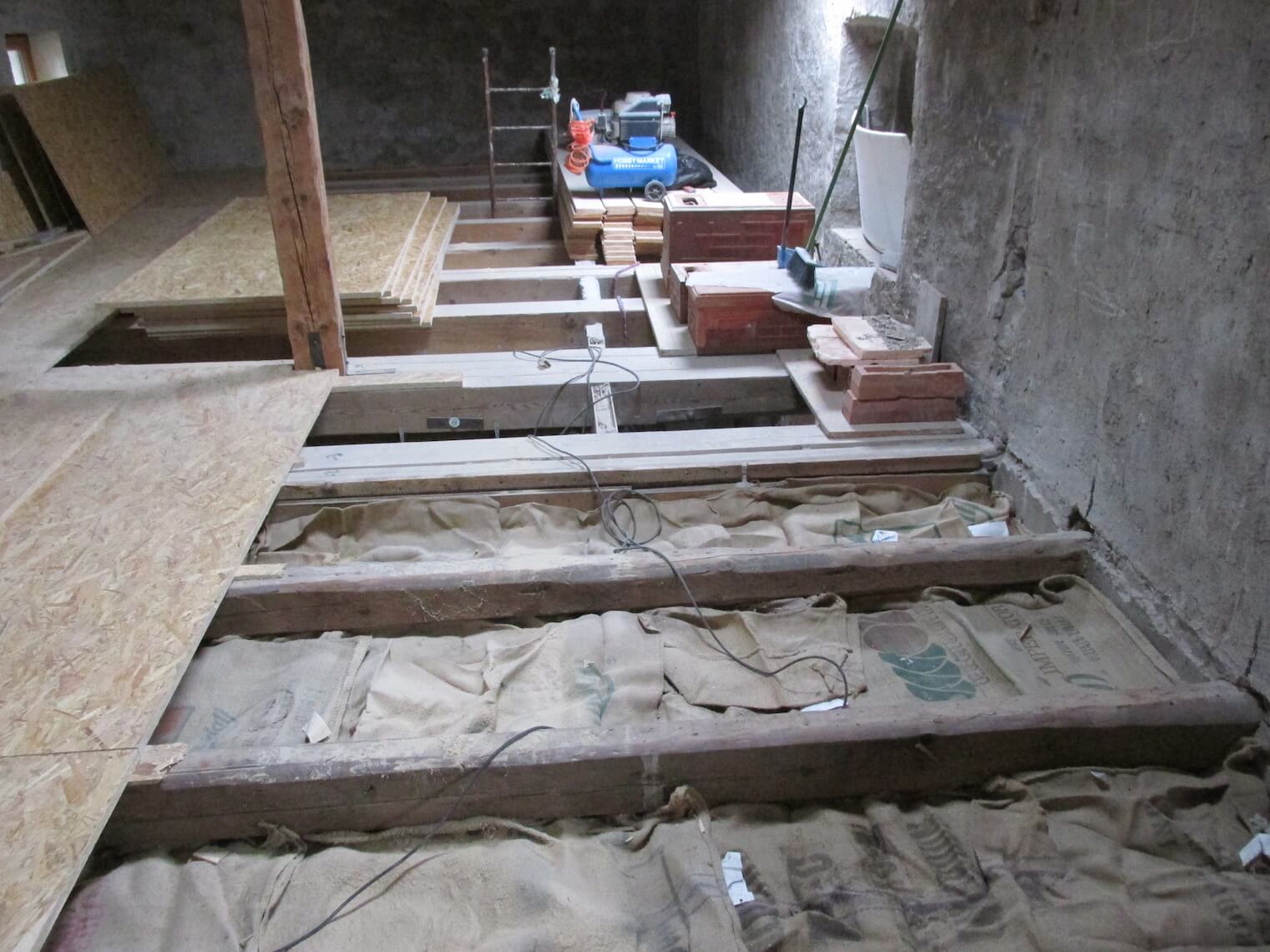 Una stanza con molte travi di legno e mattoni sul pavimento.