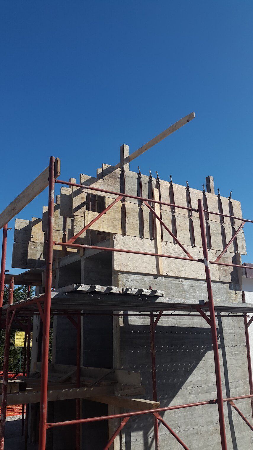 Un edificio in costruzione con impalcature e un cielo azzurro sullo sfondo