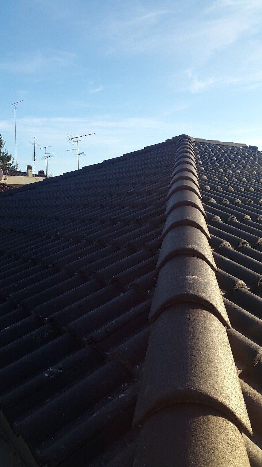 Un primo piano di un tetto con un cielo azzurro sullo sfondo