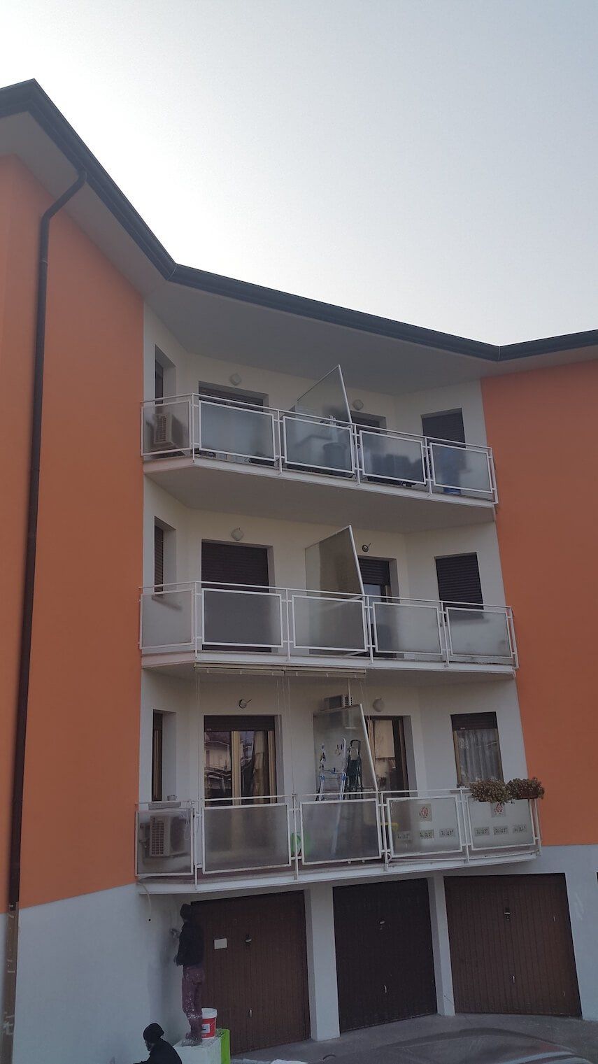 Un grande edificio arancione e bianco con balconi e garage