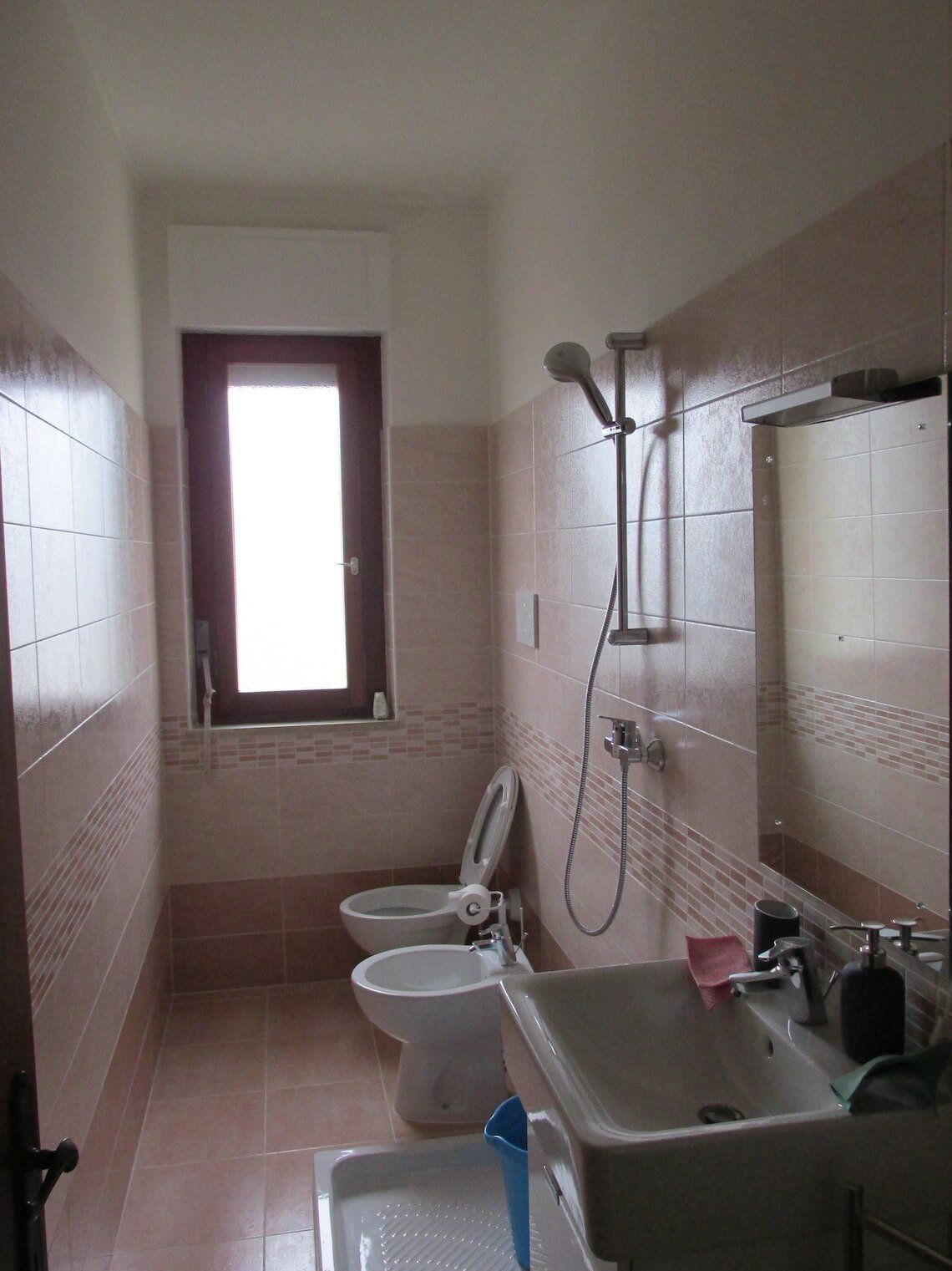 Un bagno con due wc, un lavandino e una doccia.