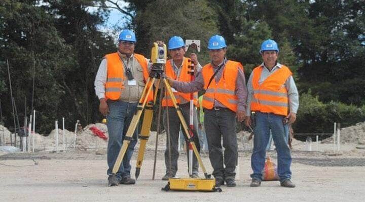 Un grupo de trabajadores de la construcción están parados uno al lado del otro.