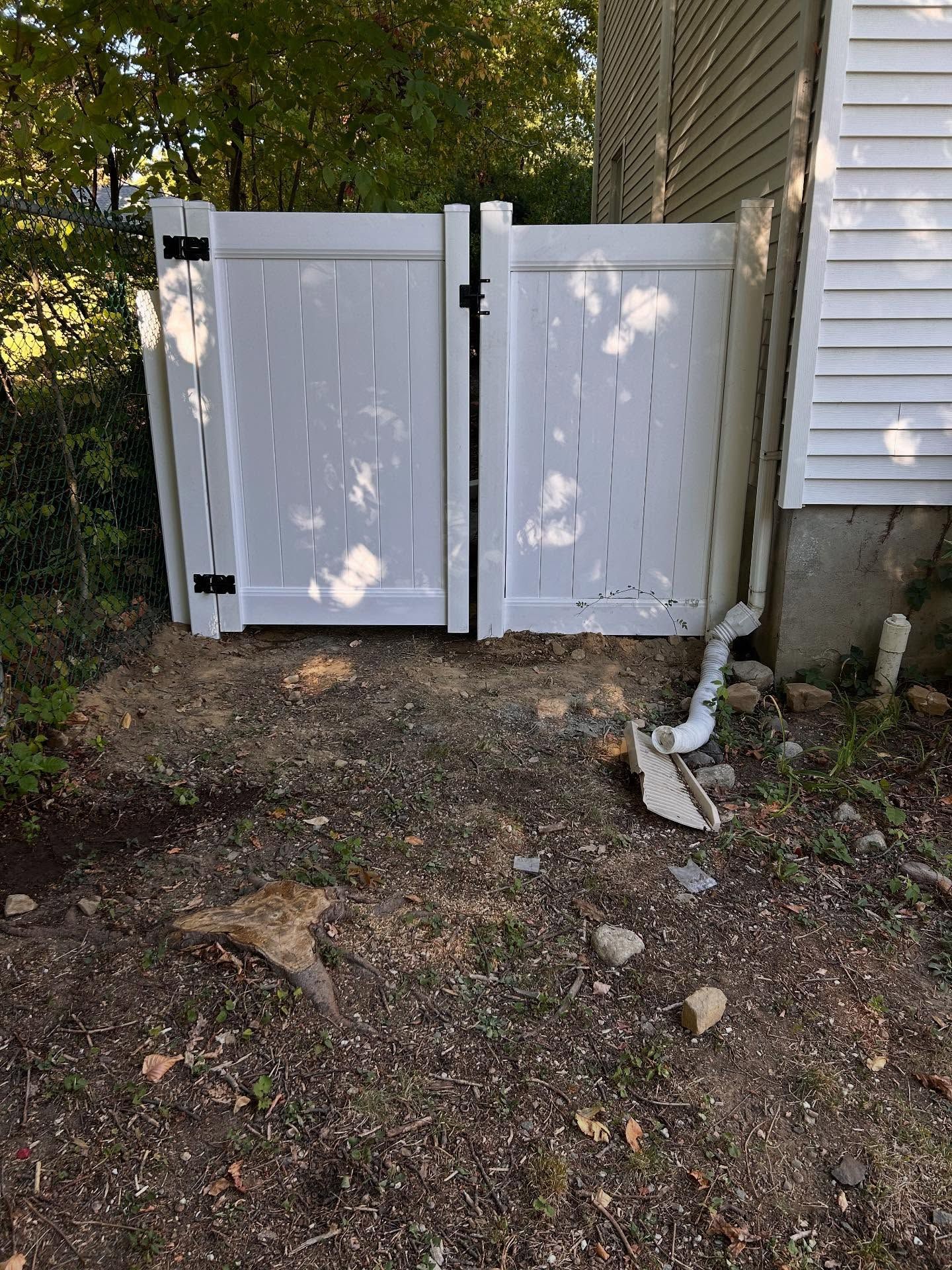 Woman in straw hat smiles, holding wine glass near a lake.