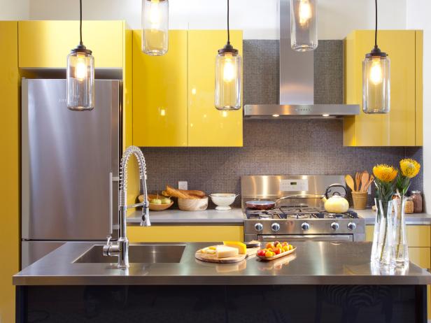 A kitchen with yellow cabinets and stainless steel appliances