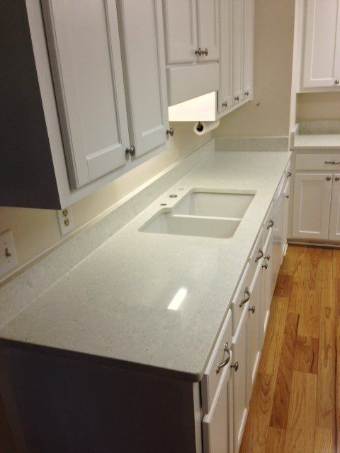 A kitchen with white cabinets and a sink