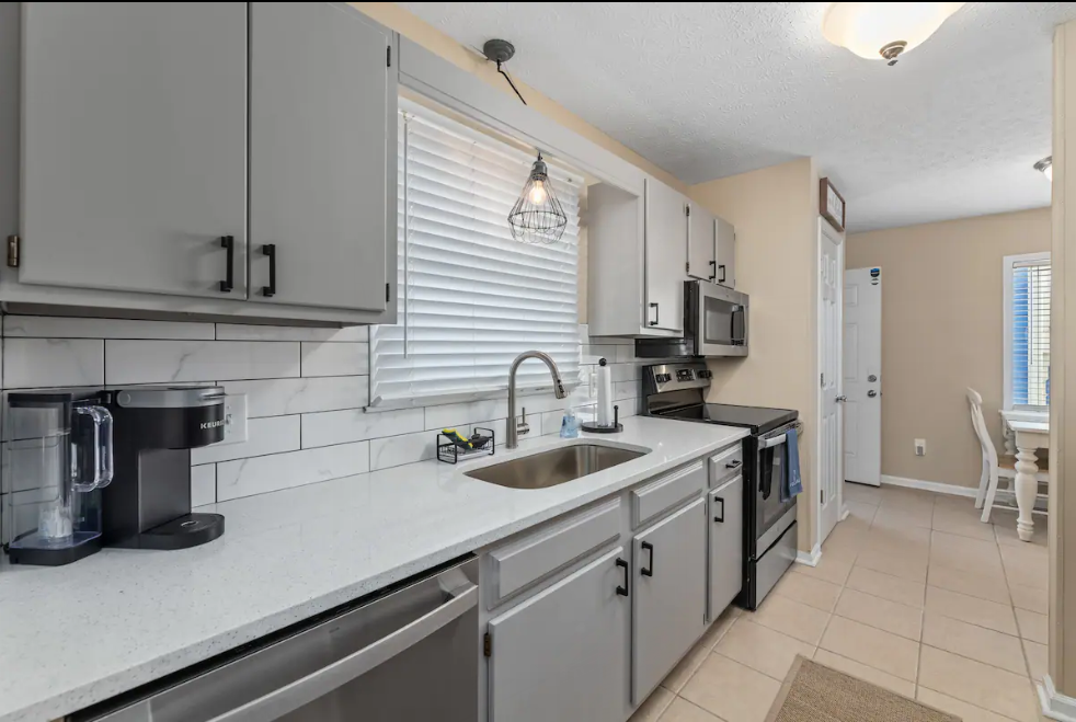 A kitchen with stainless steel appliances and white cabinets