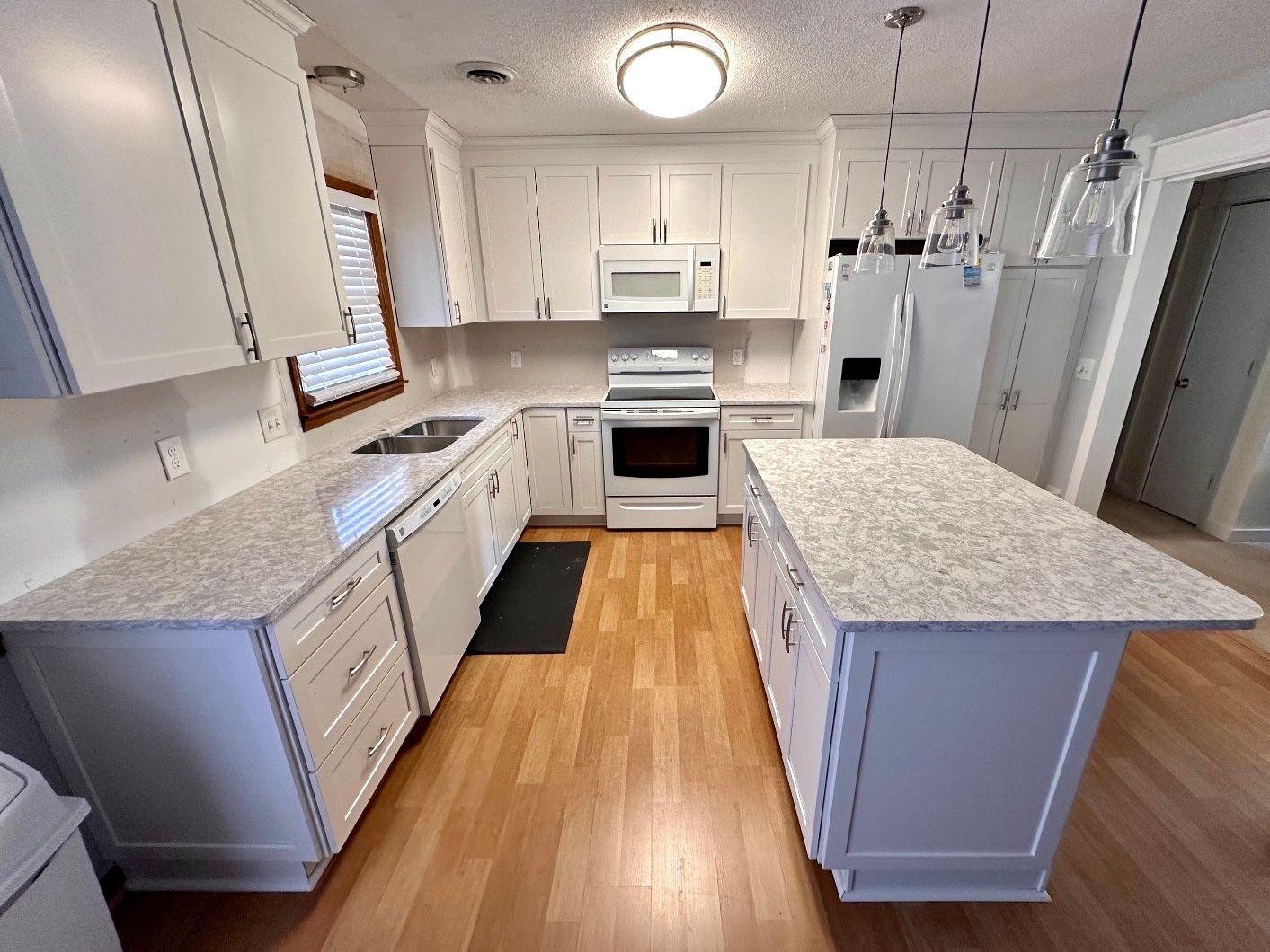 A kitchen with white cabinets and granite counter tops