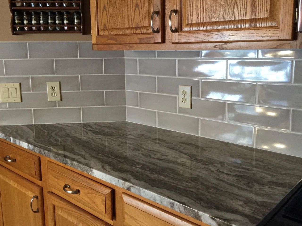 A kitchen with a granite counter top and wooden cabinets