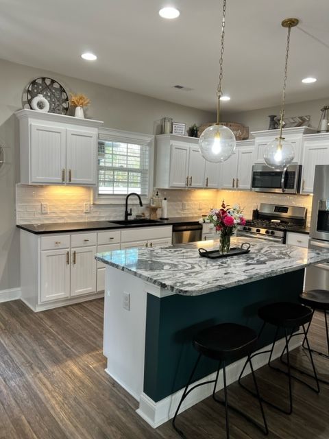 A kitchen with white cabinets and stainless steel appliances