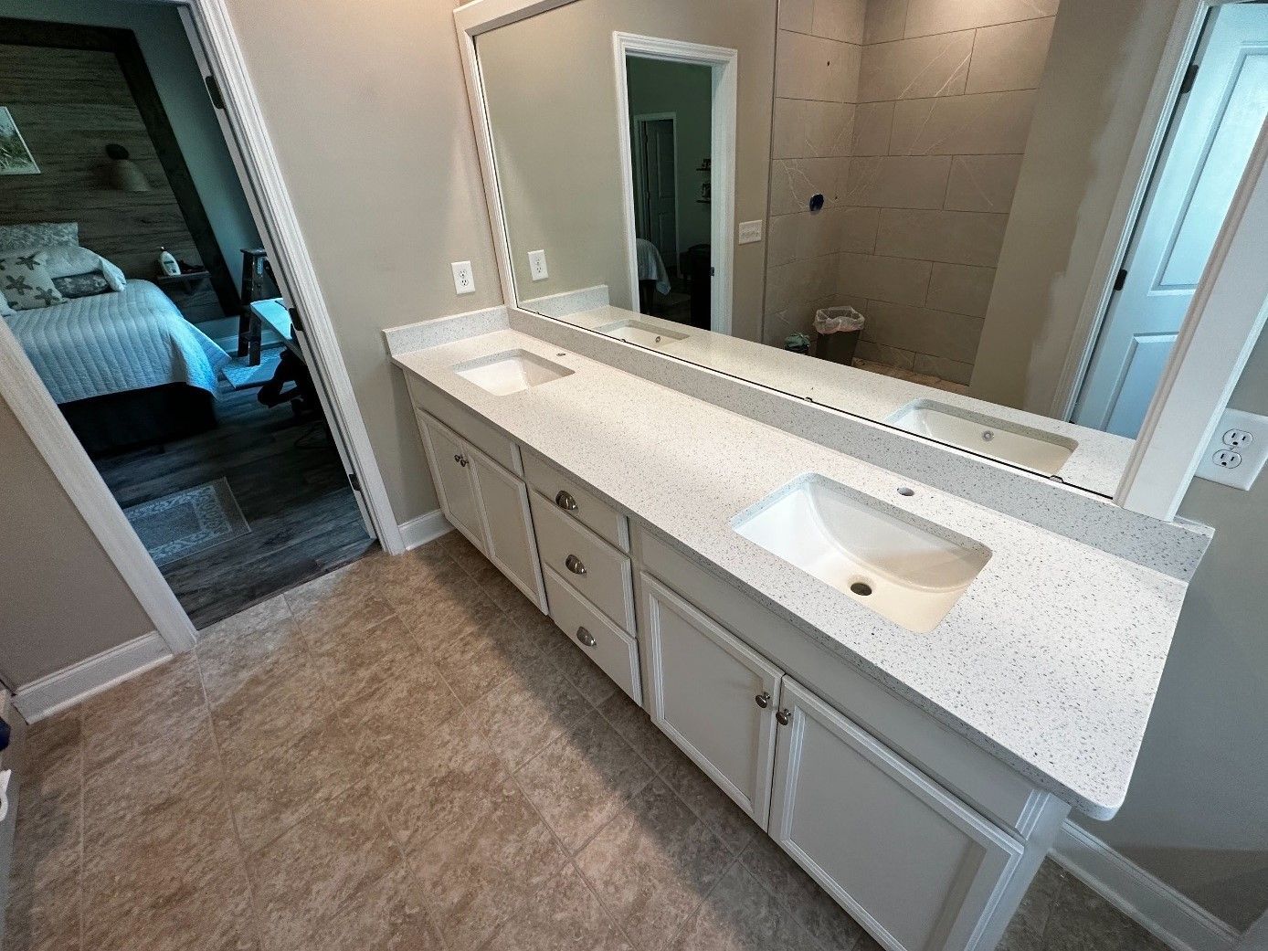 A bathroom with two sinks and a large mirror.