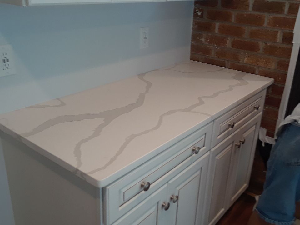 A kitchen counter with white cabinets and a white counter top