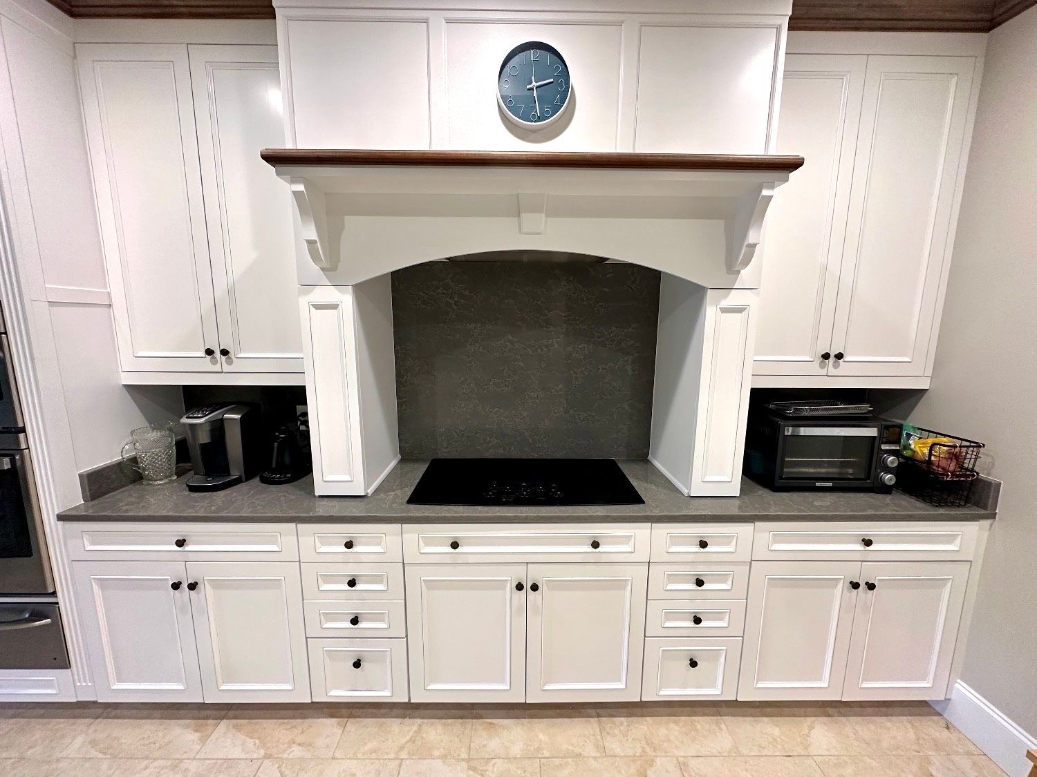 A kitchen with white cabinets and a stove top oven.