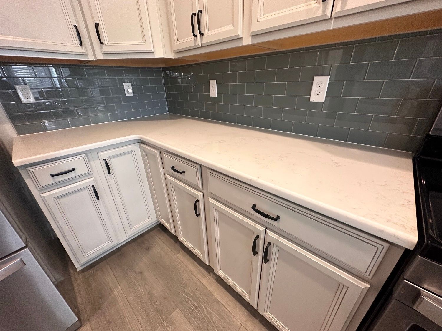 A kitchen with white cabinets and stainless steel appliances.