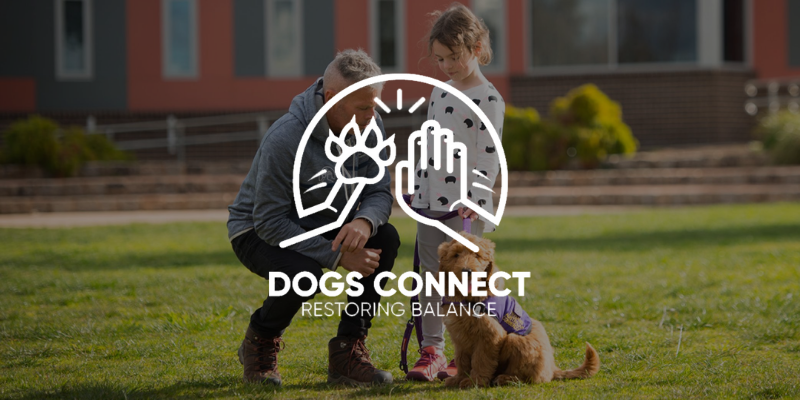 A person and child interacting with a dog on a grassy lawn. Text reads 