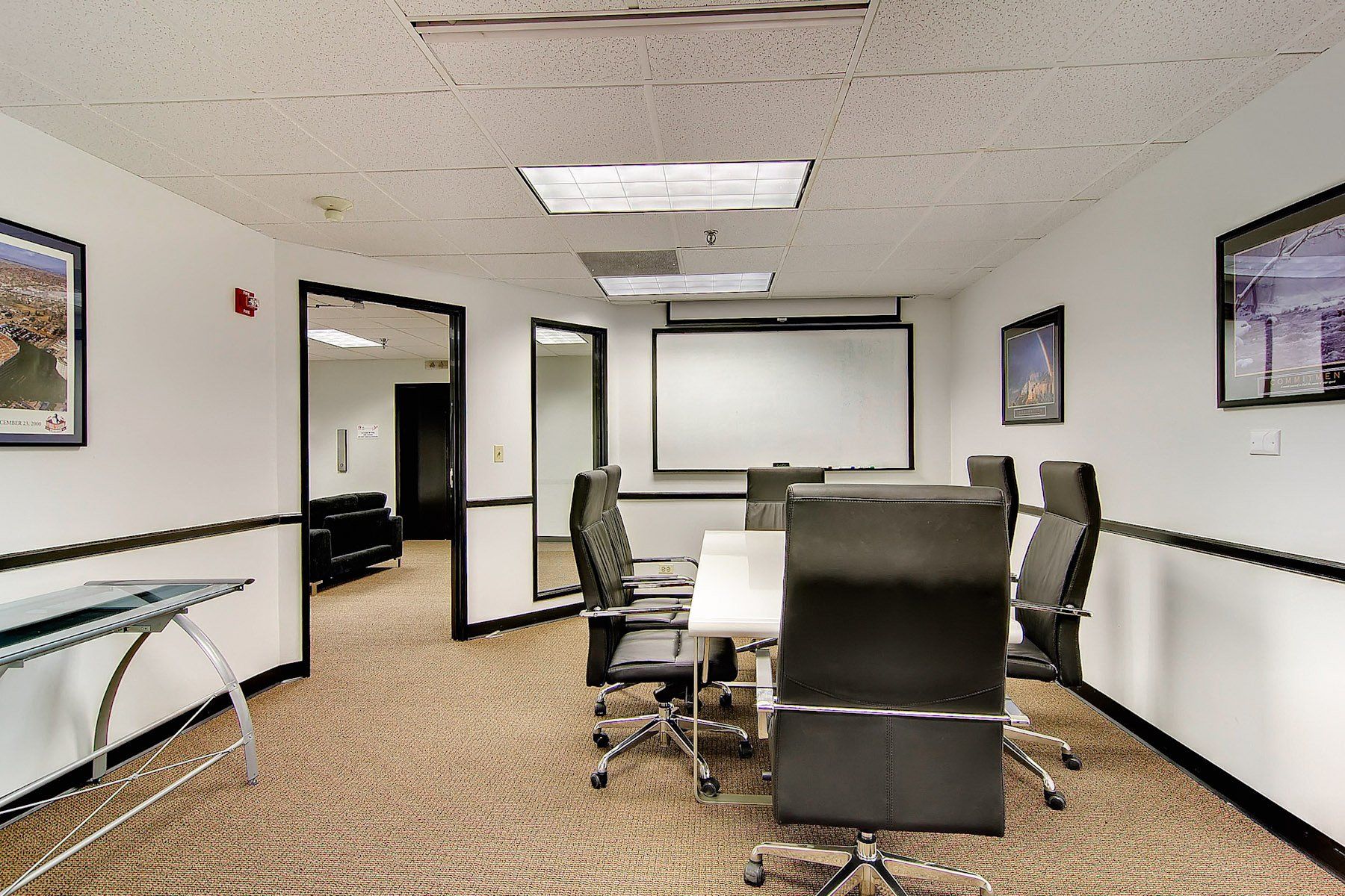 conference room with chairs, projector screen and table
