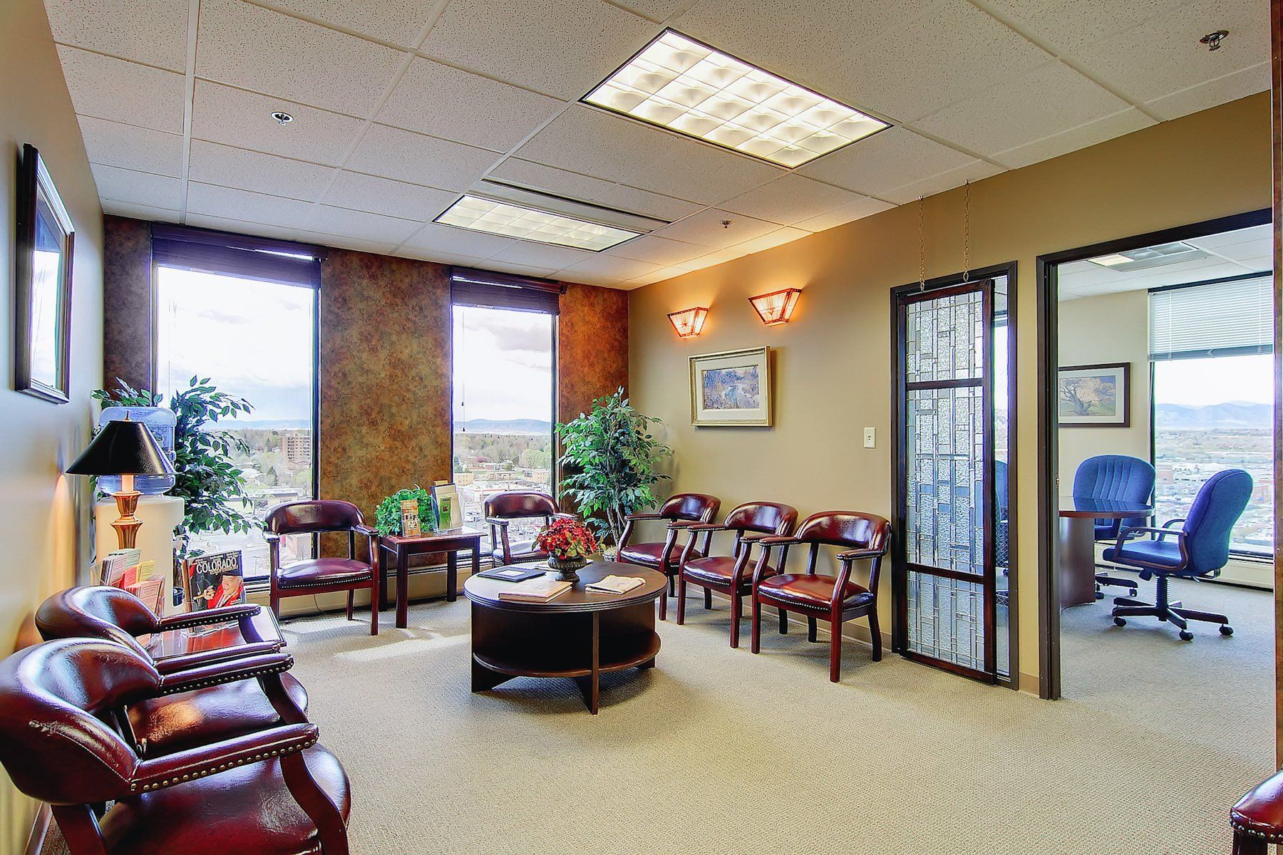 lobby outside of the conference room furnished with chairs, plants and side tables
