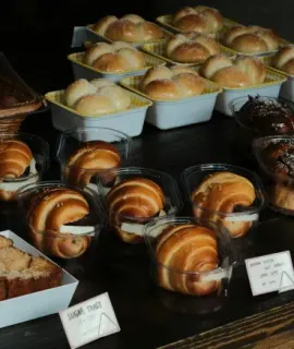 Tray of assorted pastries and rolls on a bakery display table