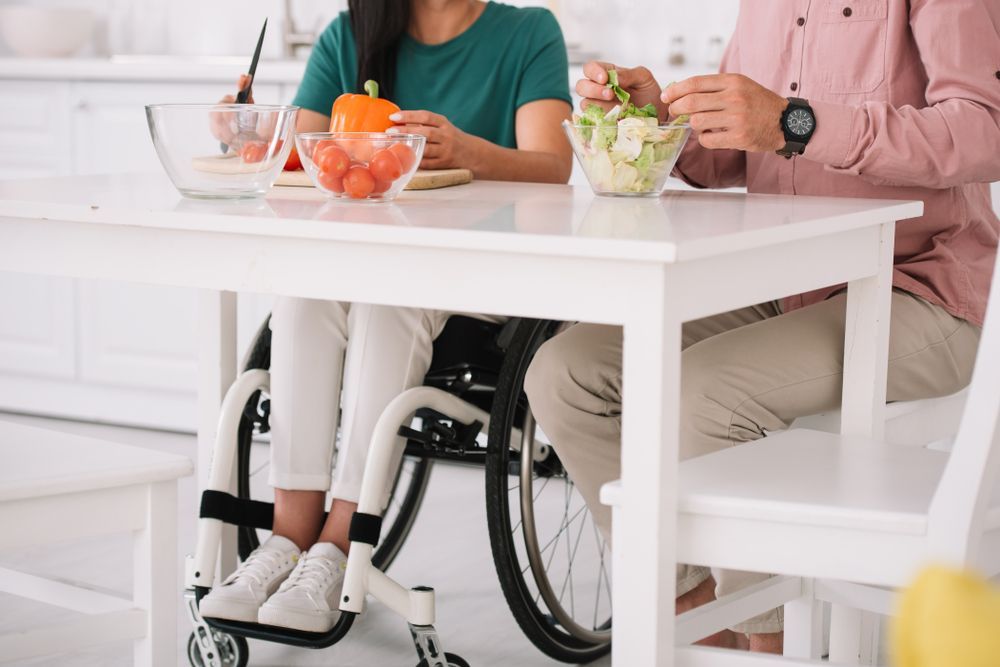 Person in a Wheelchair and Two Others Prepare Food — Sonke Support Pty. Ltd. in Caloundra, QLD
