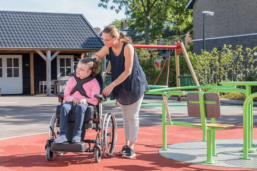 Woman Helping a Girl in a Wheelchair at a Playground — Sonke Support Pty. Ltd. in Noosa Heads, QLD