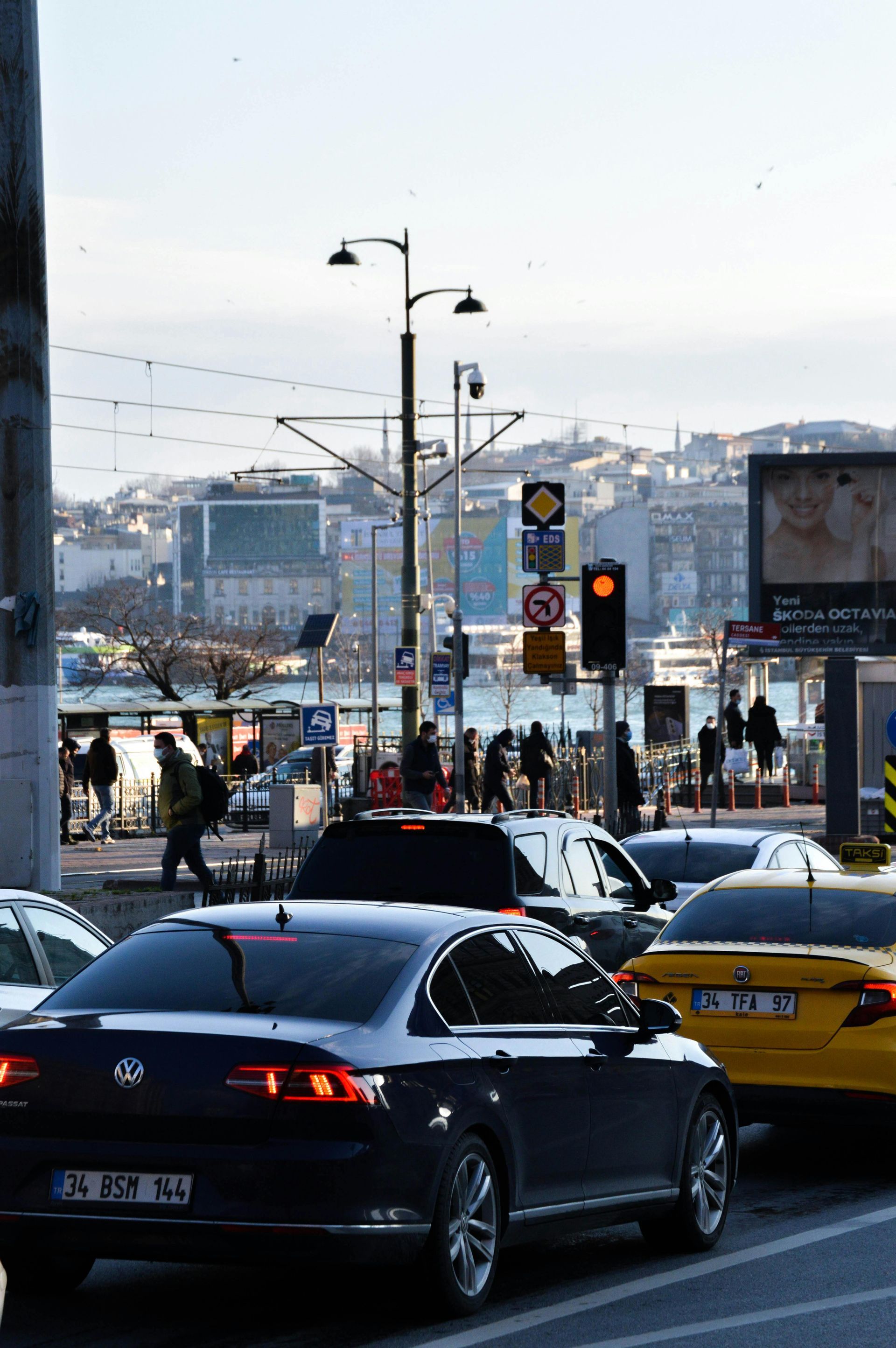 A lot of cars are driving down a street in a city.