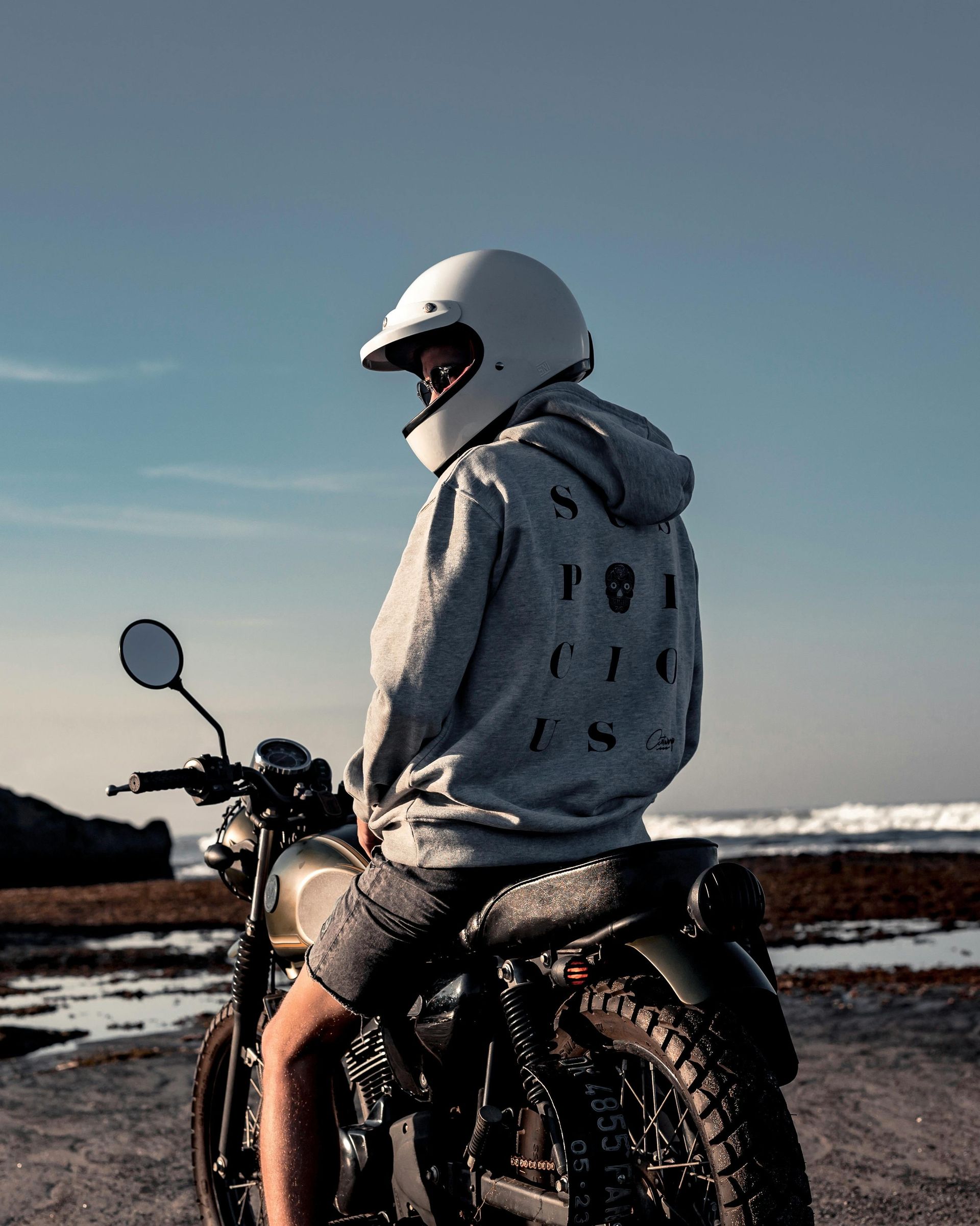 A man wearing a helmet is sitting on a motorcycle.