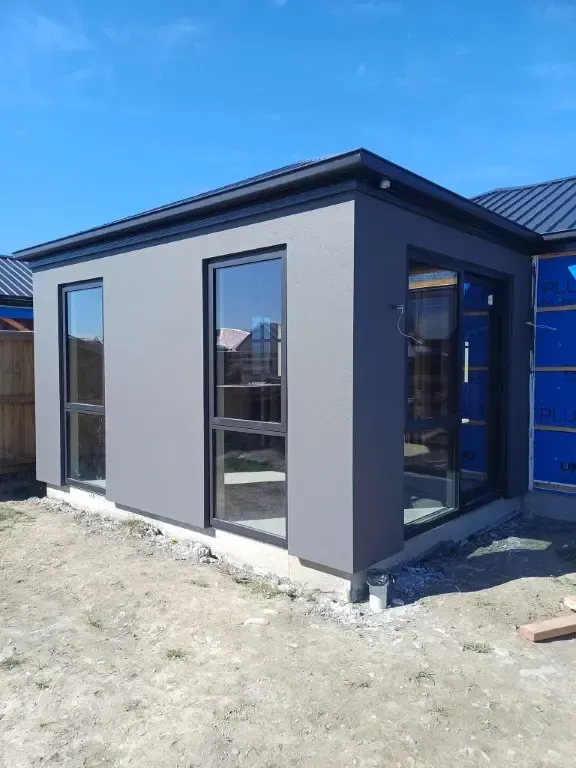 A small house with a lot of windows is being built.