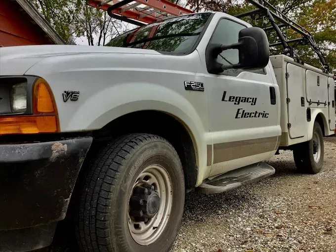 White Legacy Electric work truck with ladder on top.