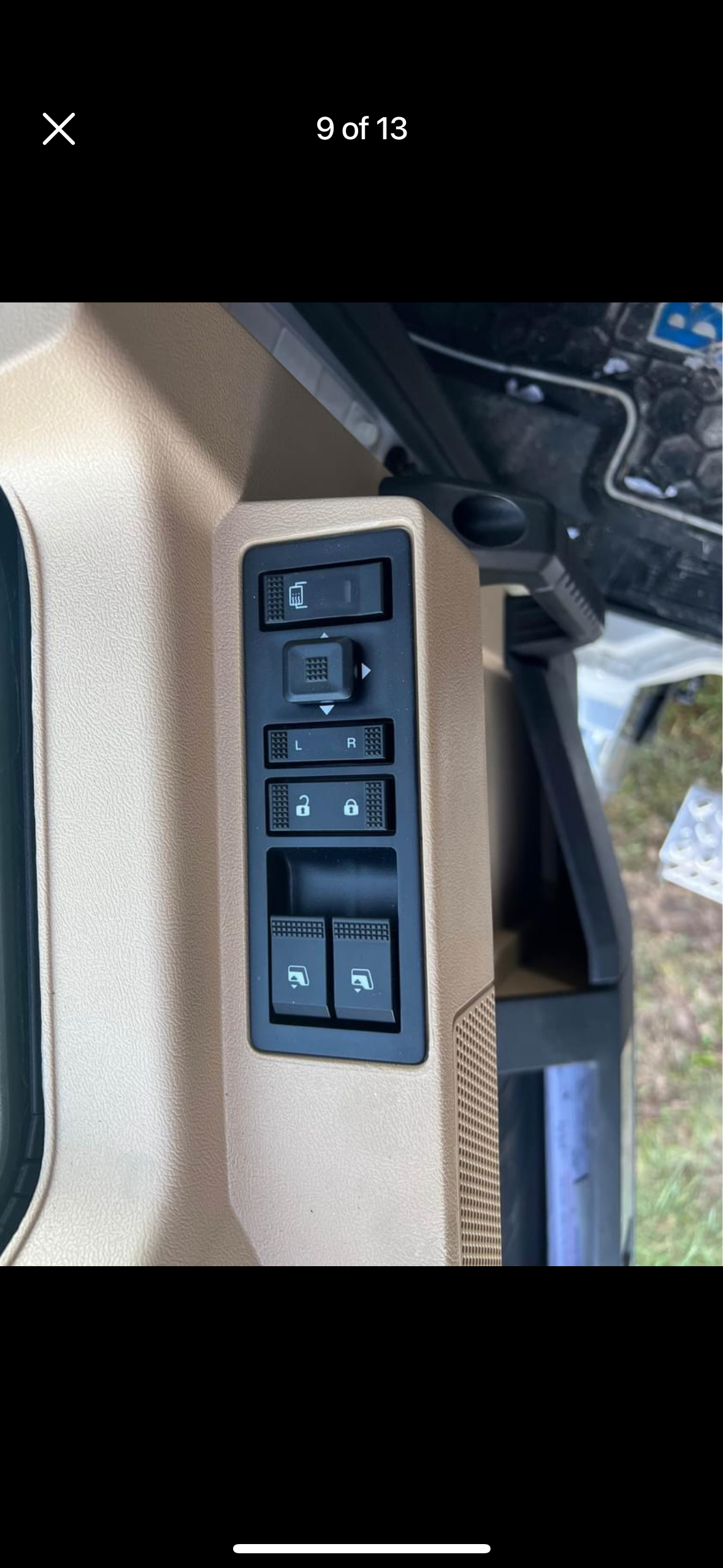A picture of a window switch on a car.