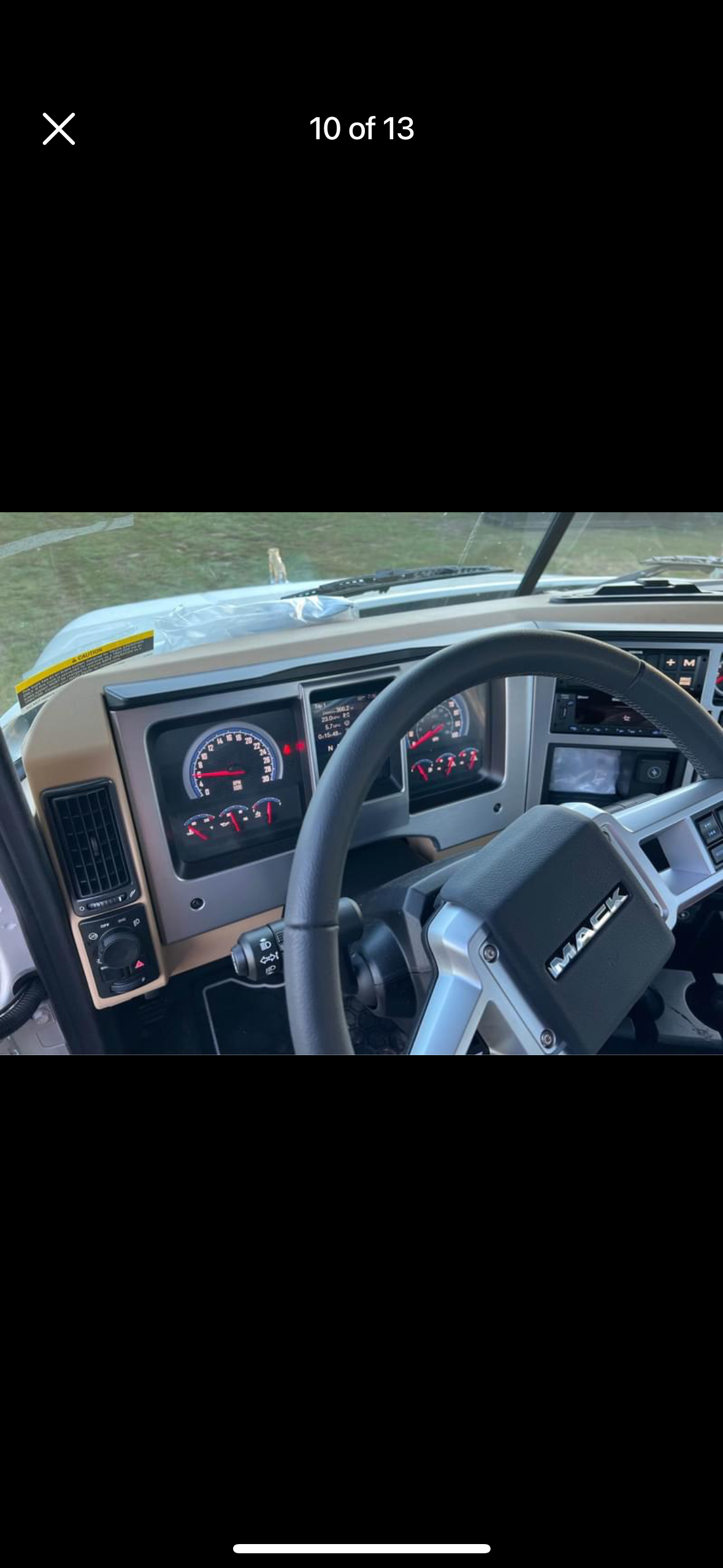 The inside of a truck with a steering wheel and dashboard.