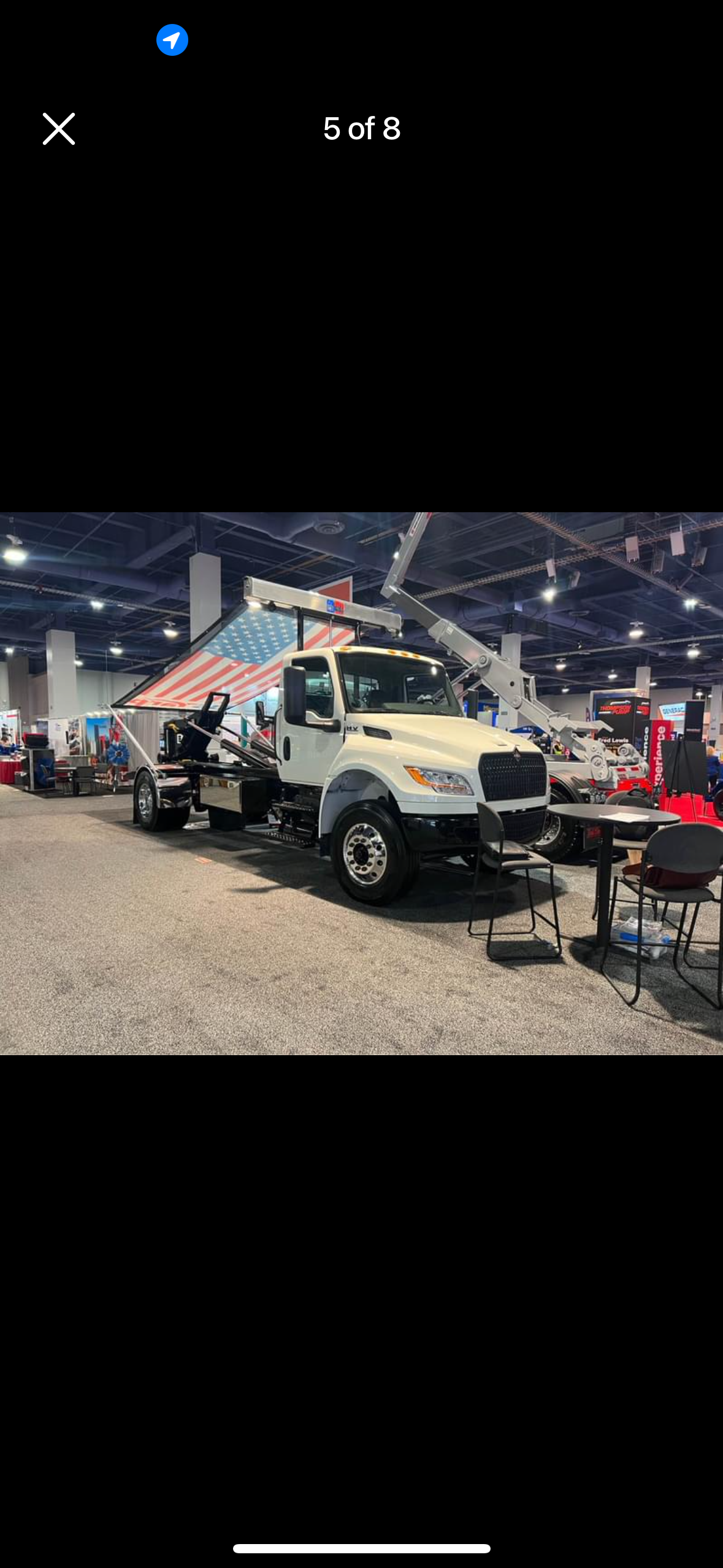 A tow truck is parked in a room at a truck show.