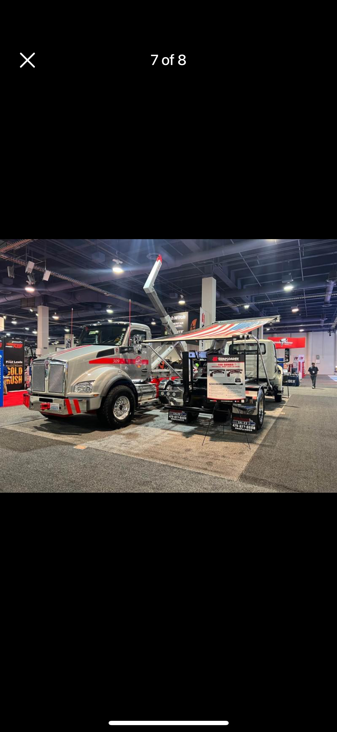 A couple of tow trucks are parked in a room.