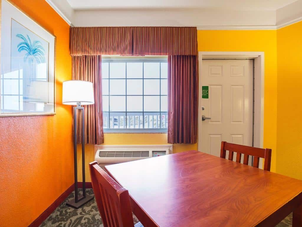 A hotel room with a table and chairs in front of a window.