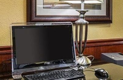 A computer is sitting on a desk next to a lamp.