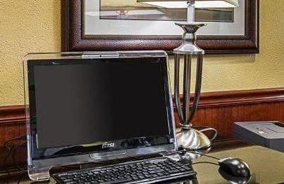 A computer is sitting on a desk next to a lamp.