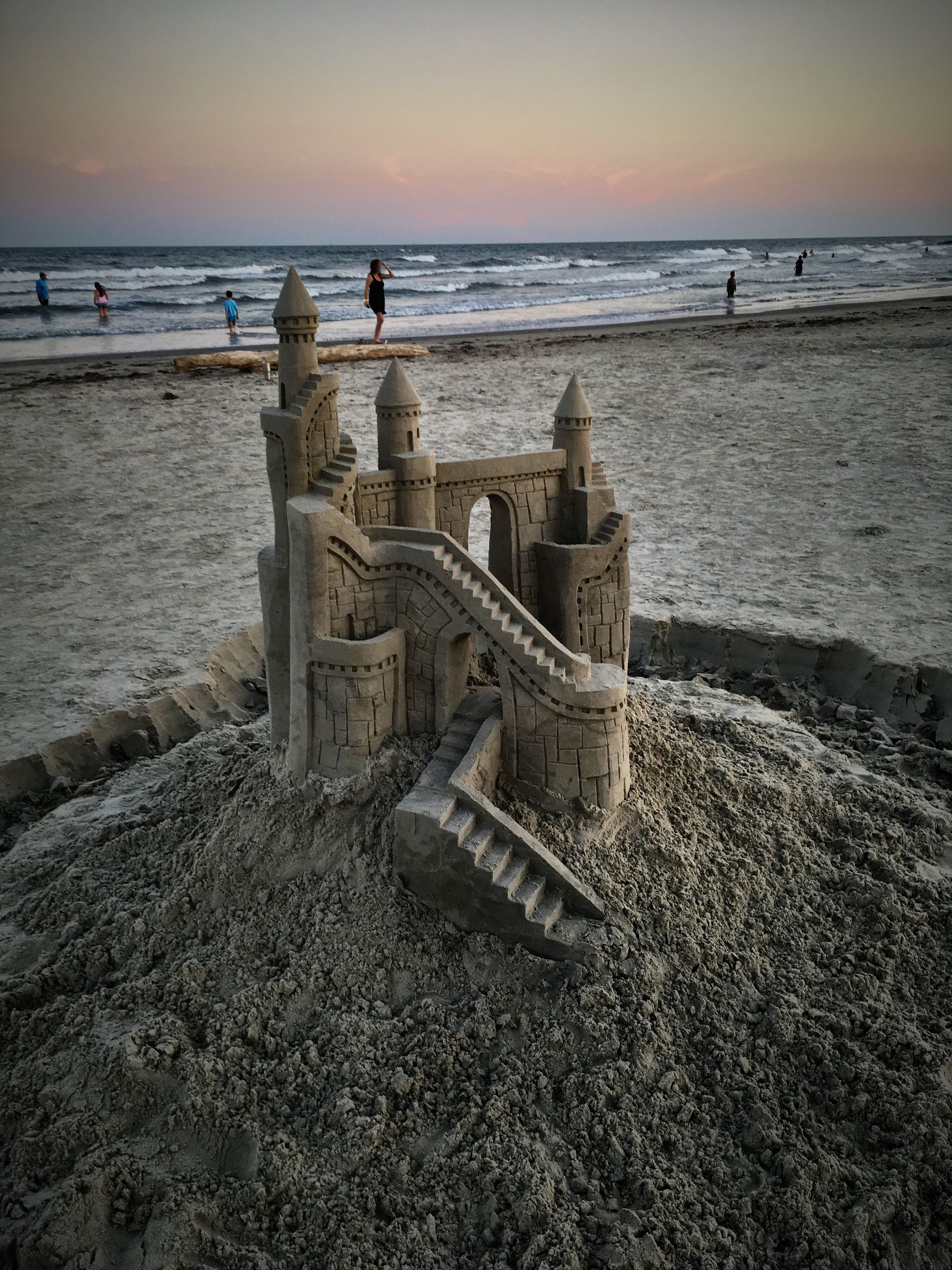 A sand castle is sitting on top of a sandy beach.