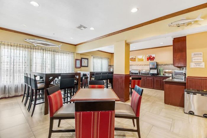 A dining room with tables and chairs in a hotel.