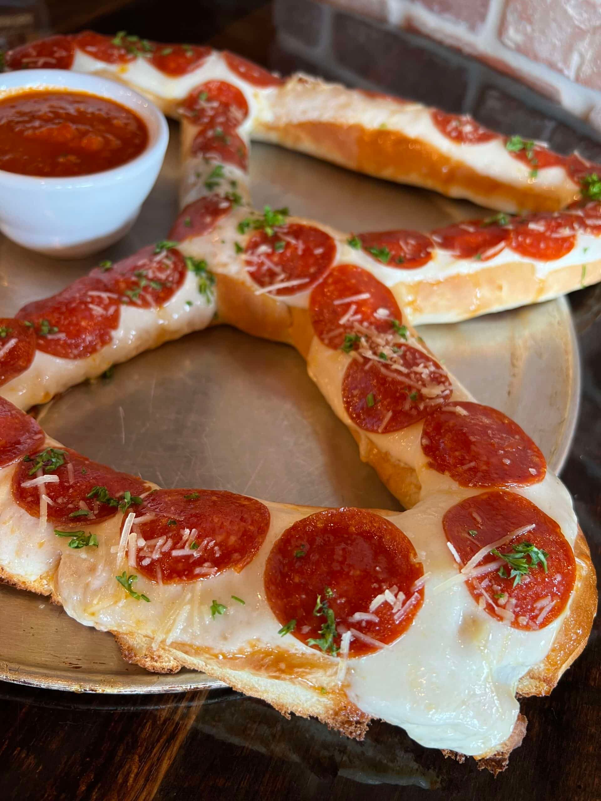 A heart shaped pizza with pepperoni and cheese on a plate.