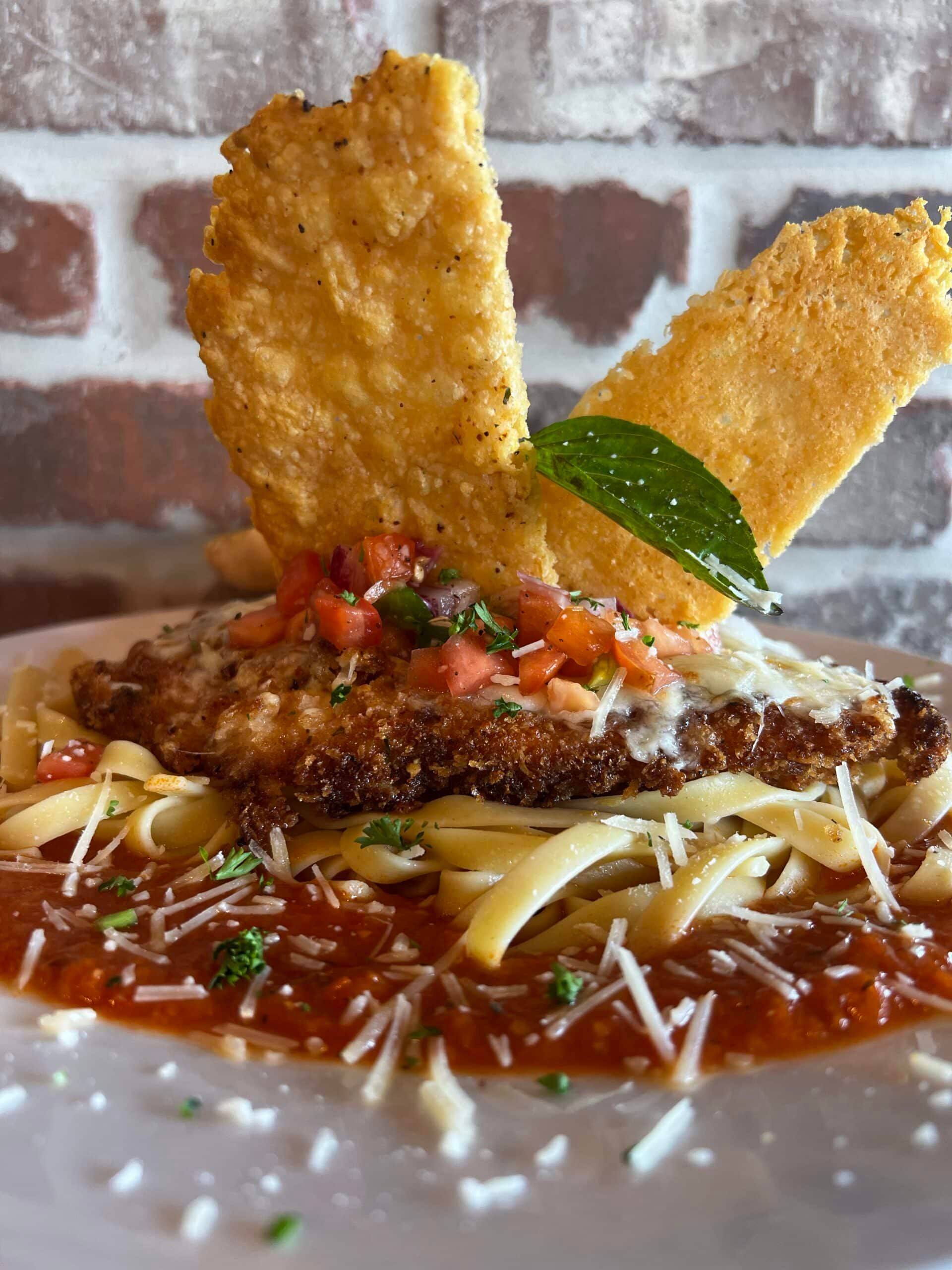 A close up of a plate of food with noodles and sauce on a table.