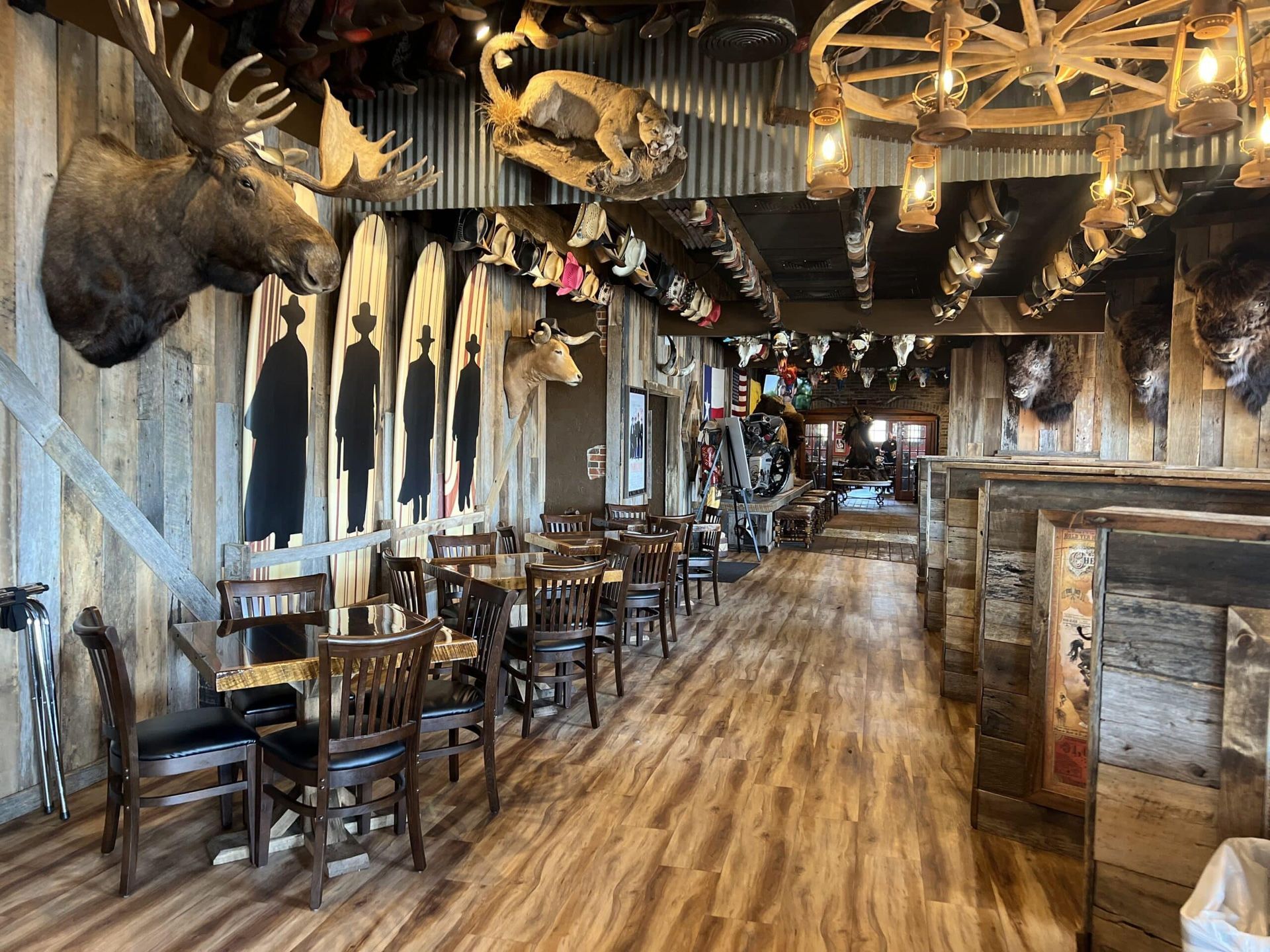 A restaurant with tables and chairs and a moose head on the wall.