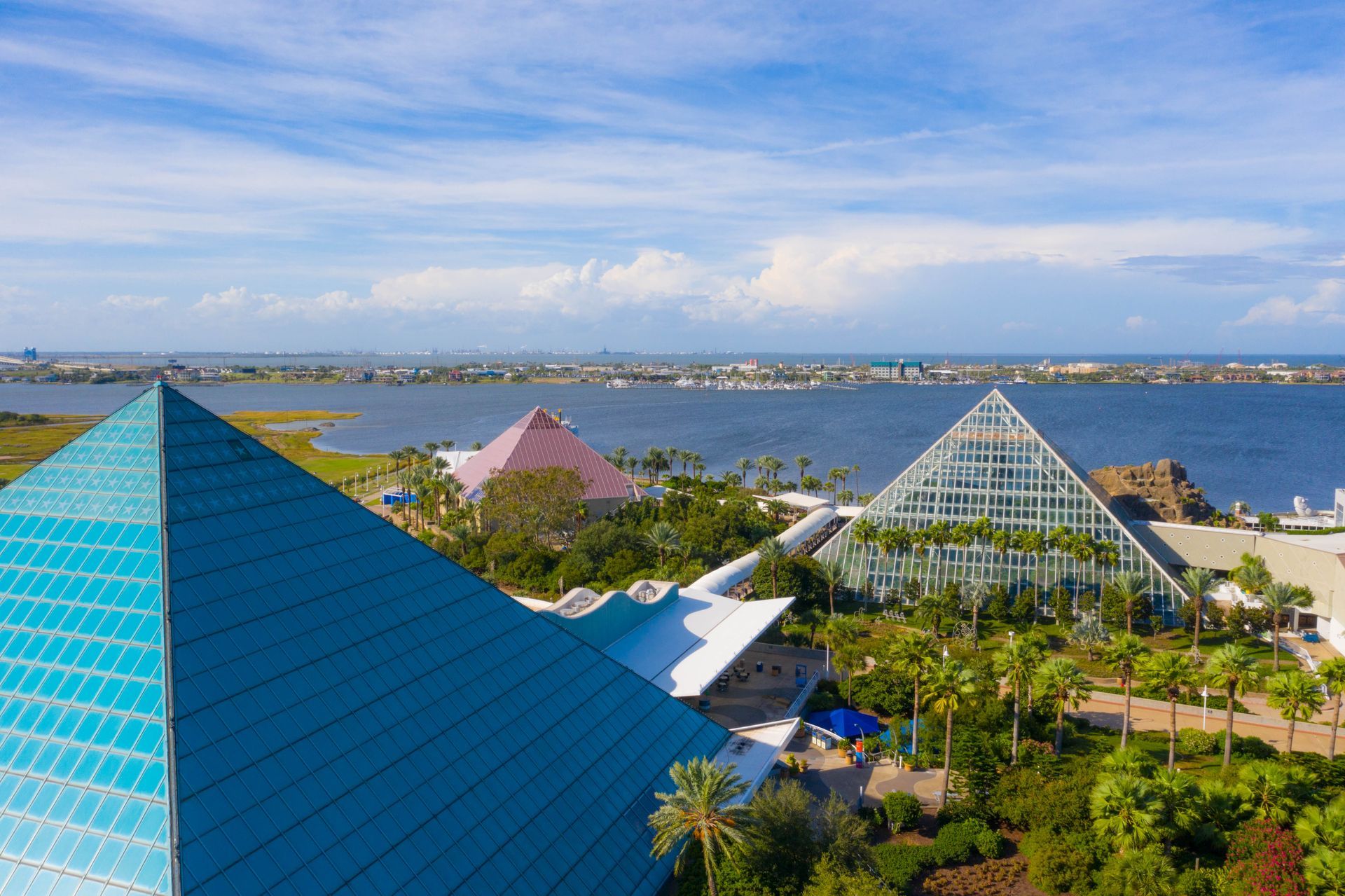 An aerial view of a pyramid shaped building next to a body of water.