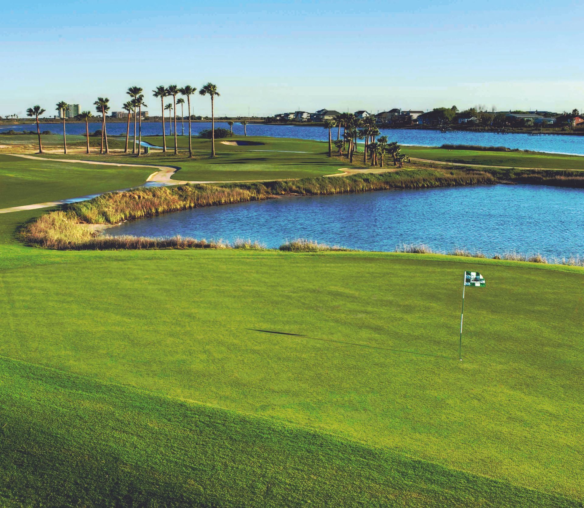 A golf course with a lake in the background
