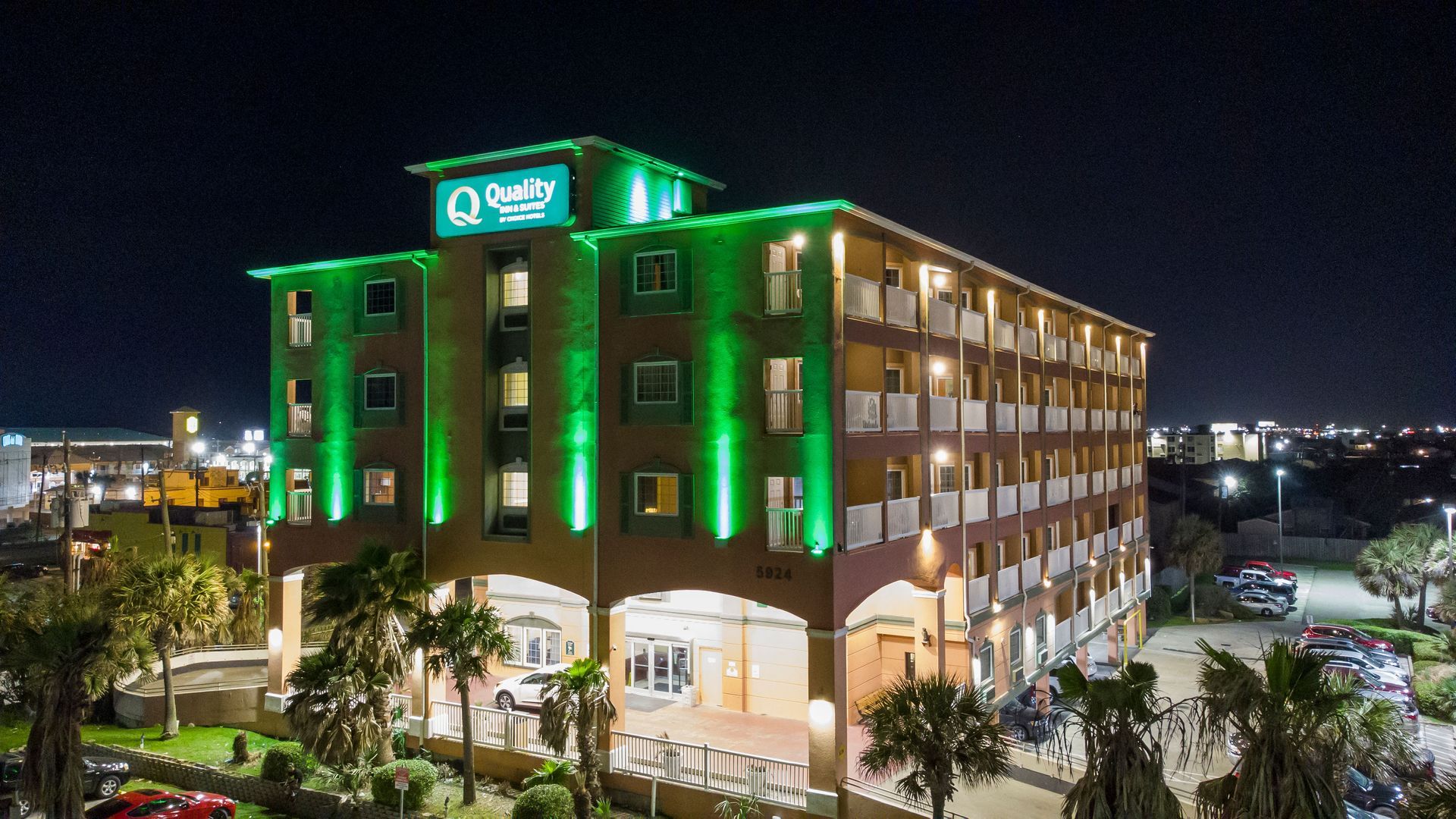 A large building with green lights on it is lit up at night.