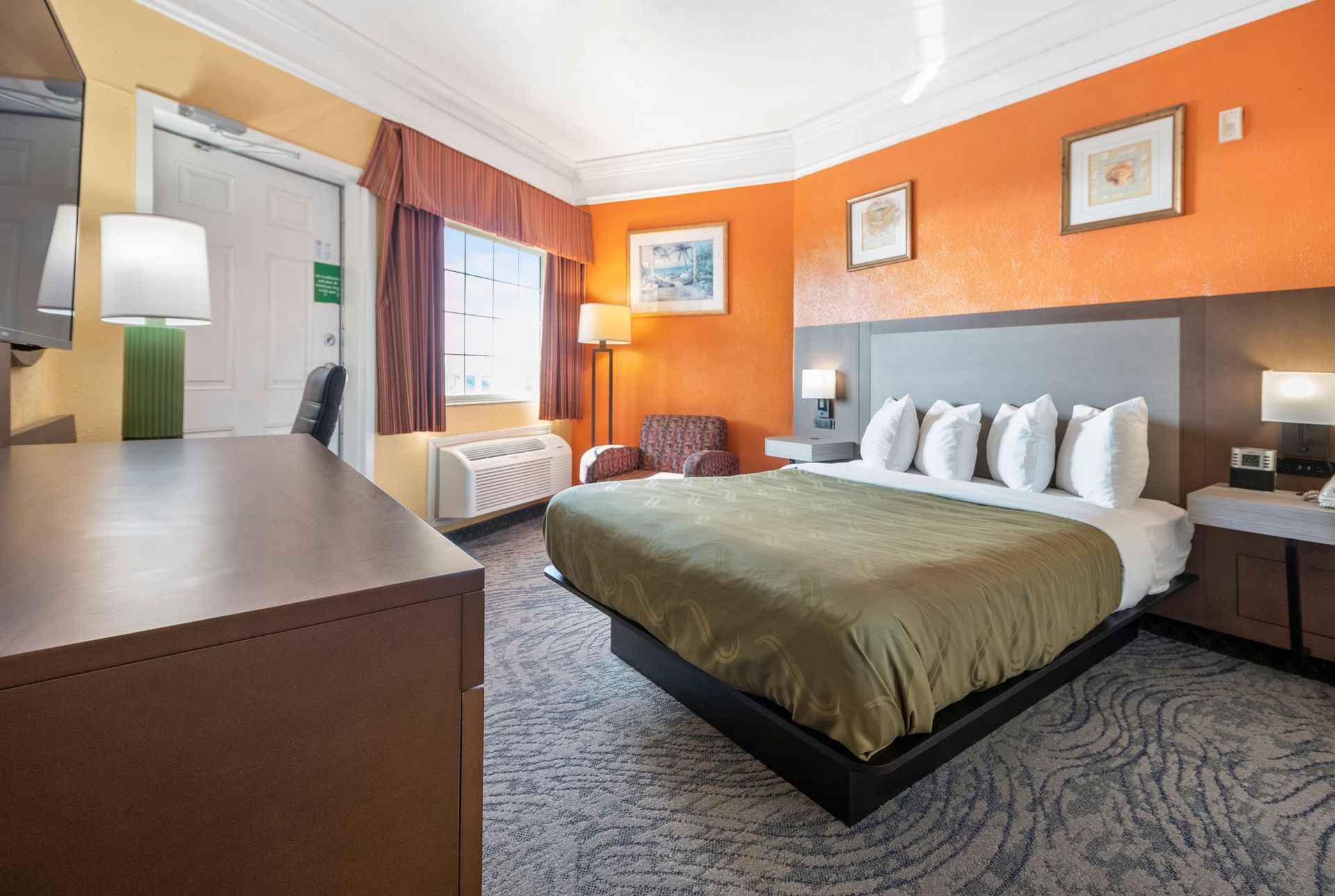 A hotel room with a table and chairs in front of a window.