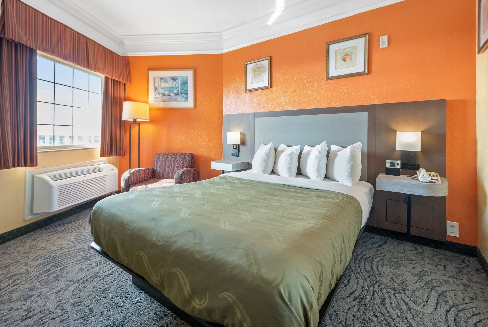 A hotel room with a table and chairs in front of a window.