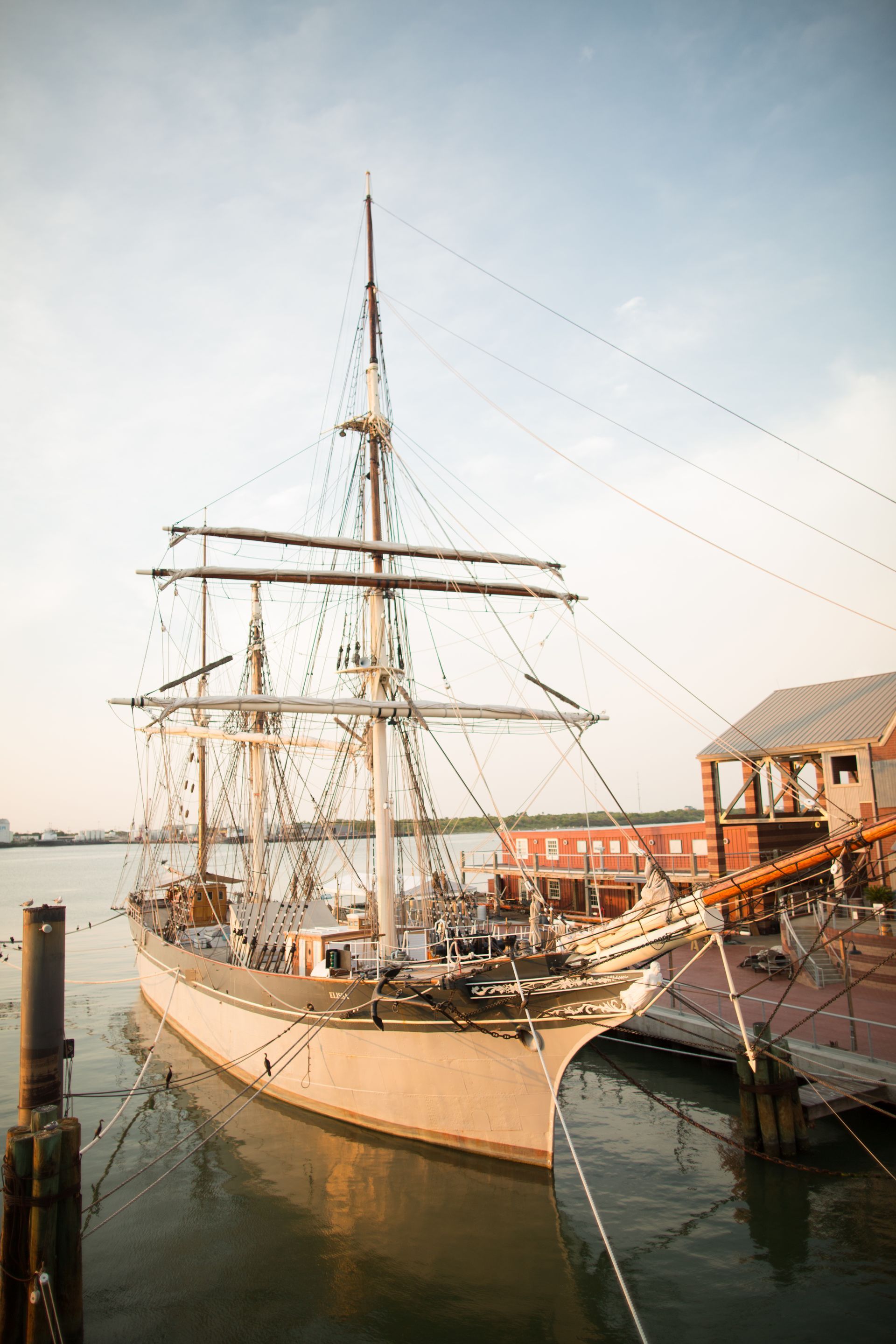 A large sailboat is docked in a harbor.