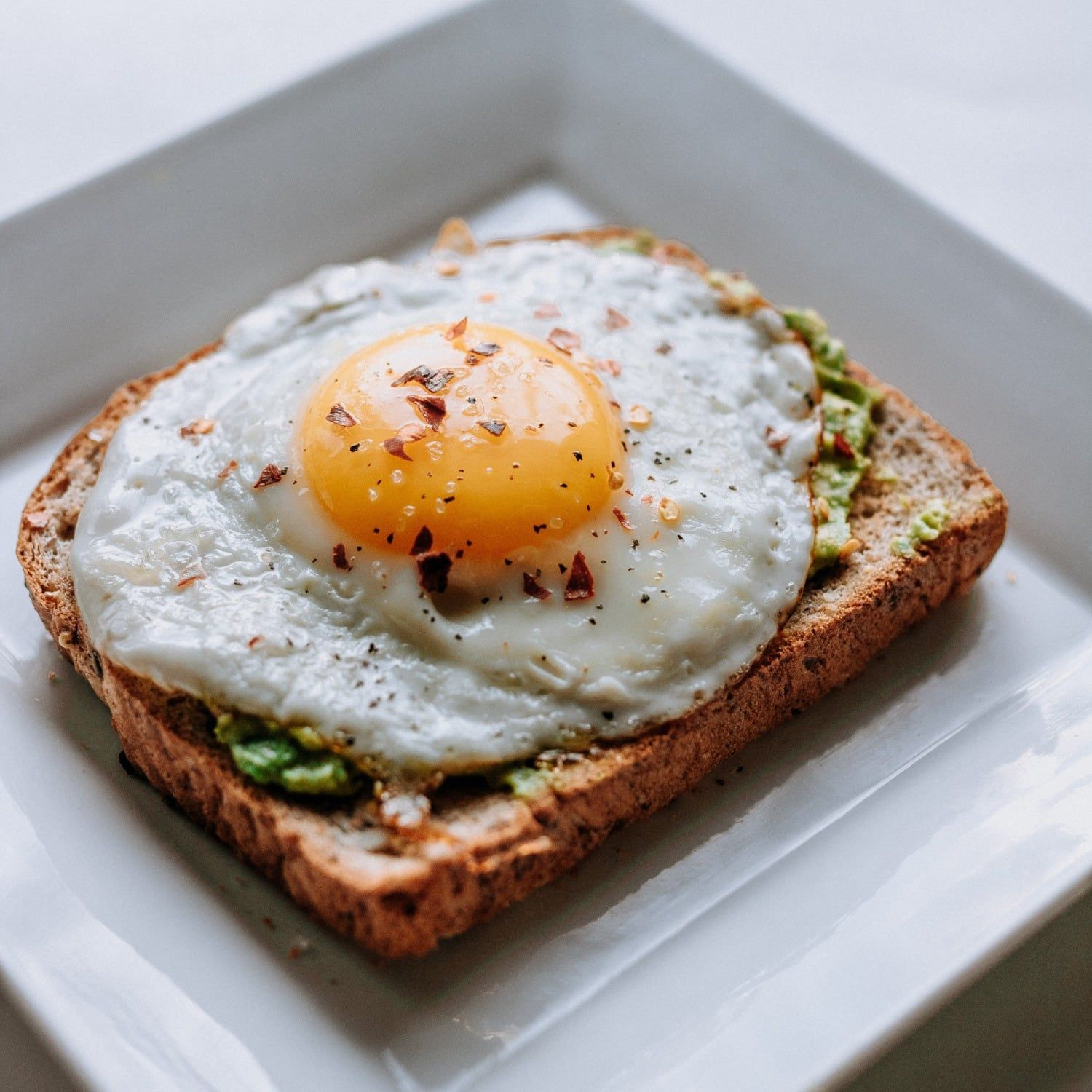 A close up of a fried egg on a piece of toast