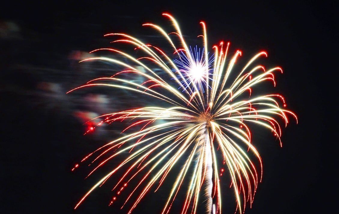 A fireworks display is going off in the night sky