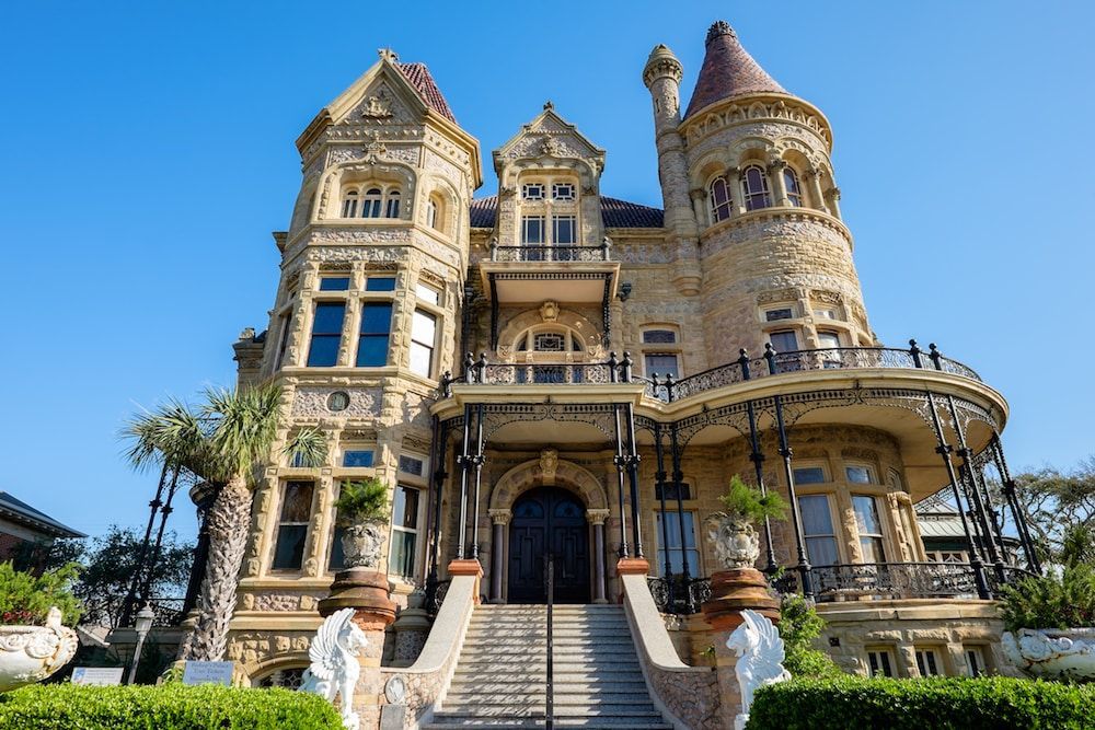 A large mansion with a staircase leading up to it.