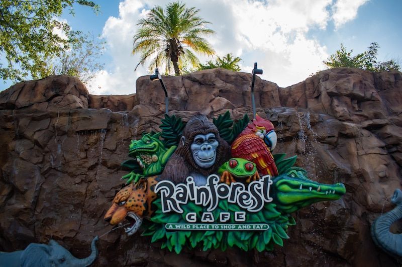 A sign for rainforest cafe with animals on it