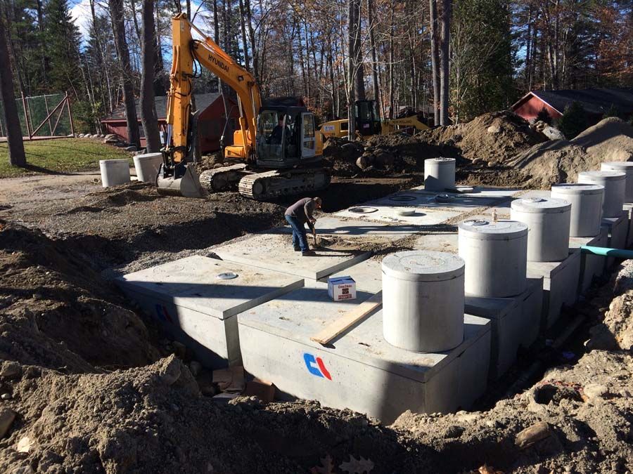 A construction worker is using a vacuum cleaner to clean the floor of a building under construction.